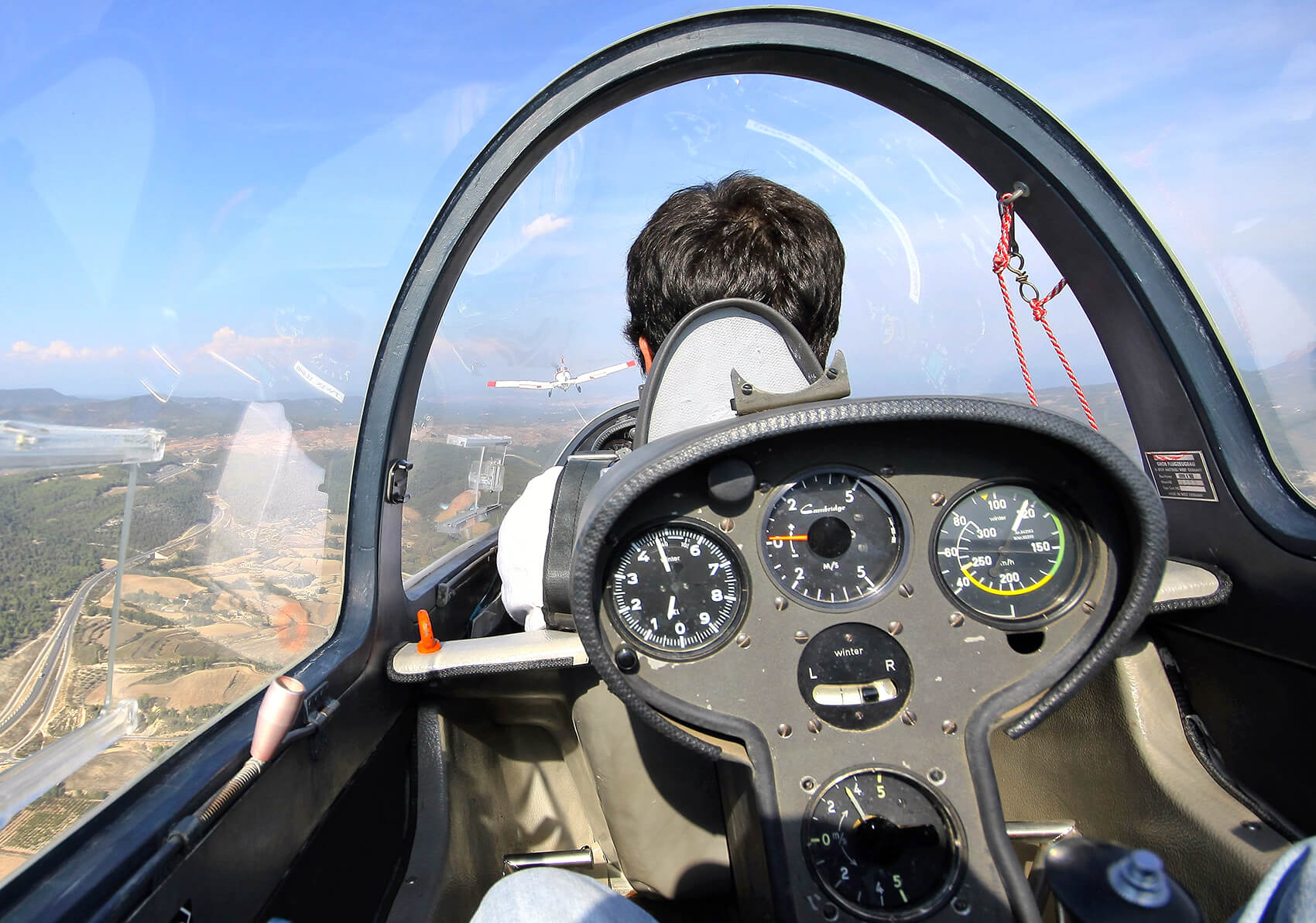 Planeador volando sobre paisaje montañoso
